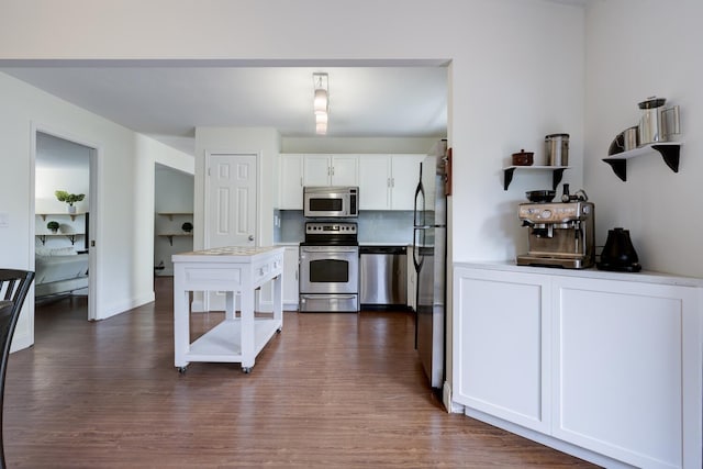 kitchen featuring white cabinets, baseboards, light countertops, appliances with stainless steel finishes, and dark wood-type flooring