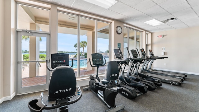 136 Lakeshore Dr Unit Ph-13, North Palm Beach, FL 33408 - exercise room featuring baseboards, a water view, a paneled ceiling, and visible vents