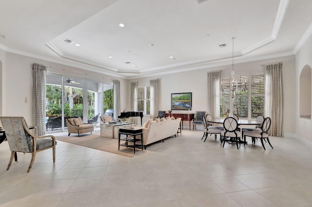 living room with crown molding, light tile patterned flooring, and a raised ceiling