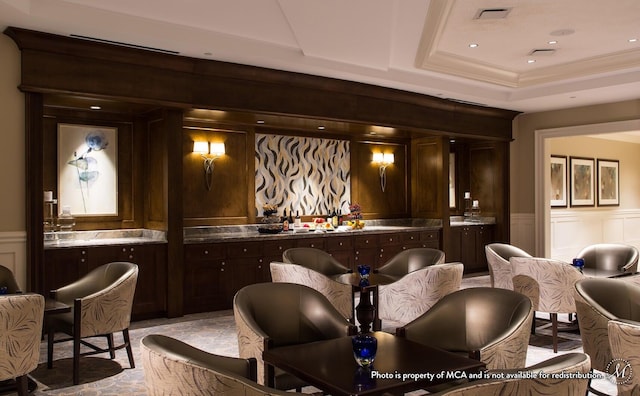 bar featuring a wainscoted wall, visible vents, a decorative wall, and a tray ceiling