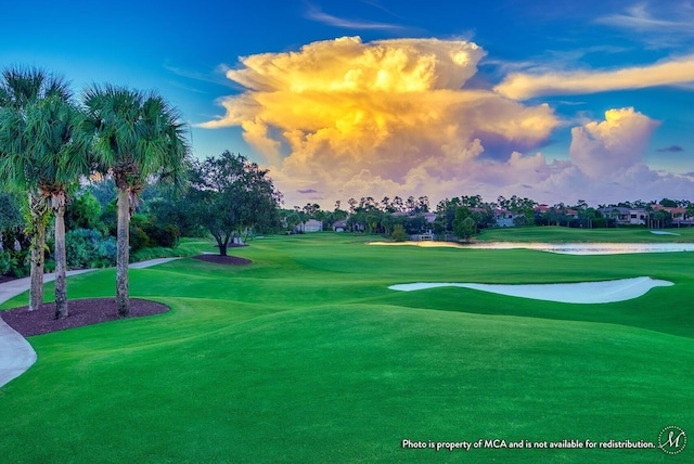 view of home's community featuring golf course view and a lawn