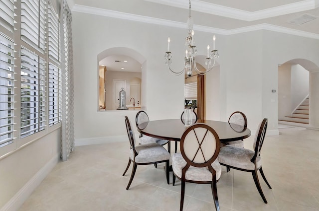 dining space with an inviting chandelier, baseboards, ornamental molding, and arched walkways