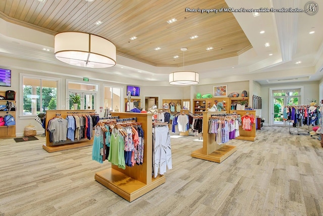interior space featuring wooden ceiling, light wood-type flooring, a tray ceiling, baseboards, and ornamental molding