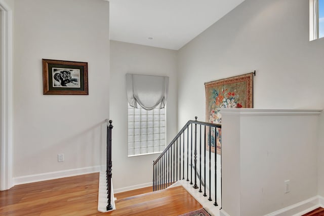 stairs featuring wood finished floors and baseboards