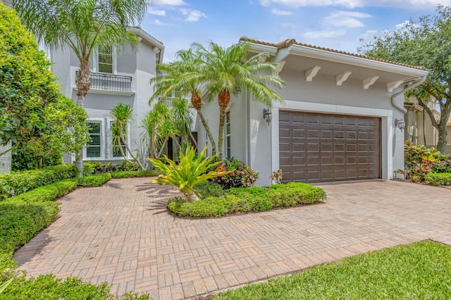 view of front of property with decorative driveway, stucco siding, and a garage