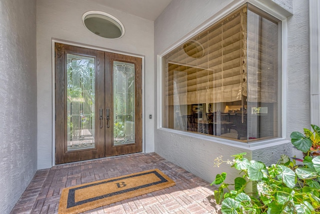 view of exterior entry with stucco siding and french doors
