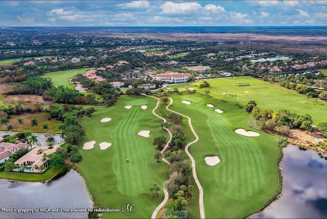 aerial view with golf course view, a residential view, and a water view