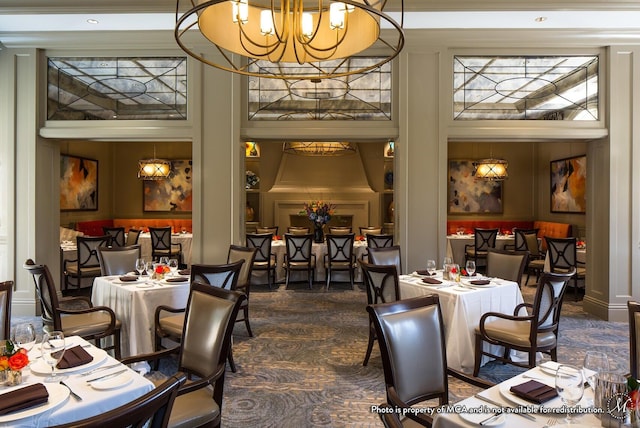 carpeted dining area featuring a chandelier, a high ceiling, and crown molding