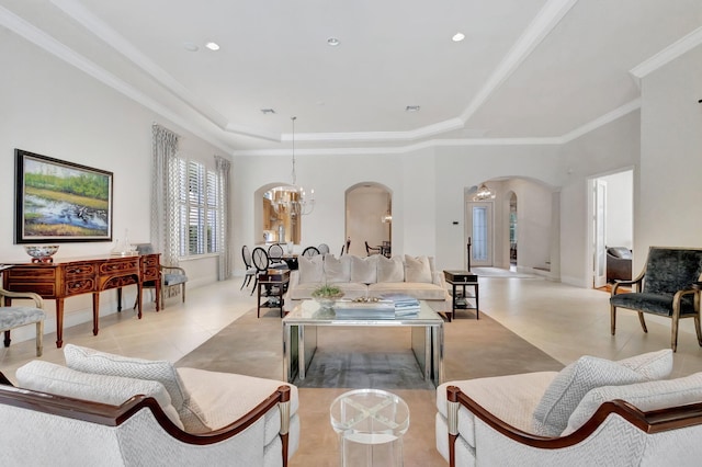 living room featuring arched walkways, light tile patterned floors, ornamental molding, a notable chandelier, and a tray ceiling