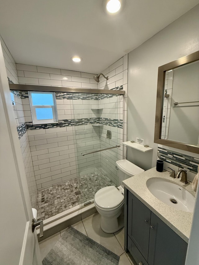 full bathroom with toilet, a shower stall, tile patterned flooring, and vanity