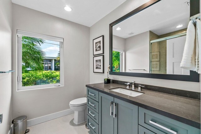 225 NW 11th St, Delray Beach, FL 33444 - bathroom featuring toilet, baseboards, vanity, a stall shower, and tile patterned flooring