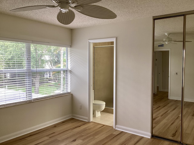 2415 SW Danbury Ln, Palm City, FL 34990 - unfurnished bedroom featuring visible vents, light wood-style floors, baseboards, a textured ceiling, and a ceiling fan