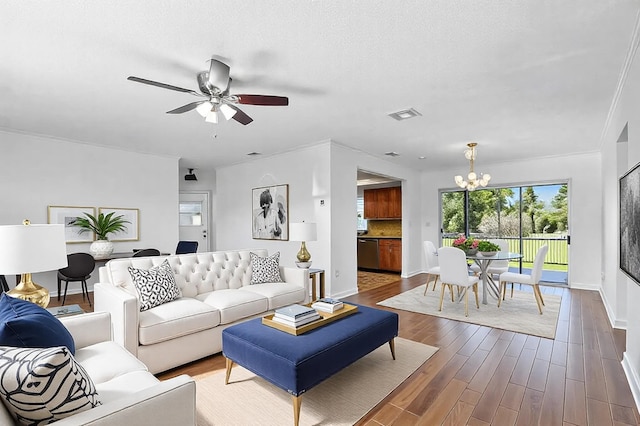 living area with baseboards, visible vents, wood finished floors, and ceiling fan with notable chandelier