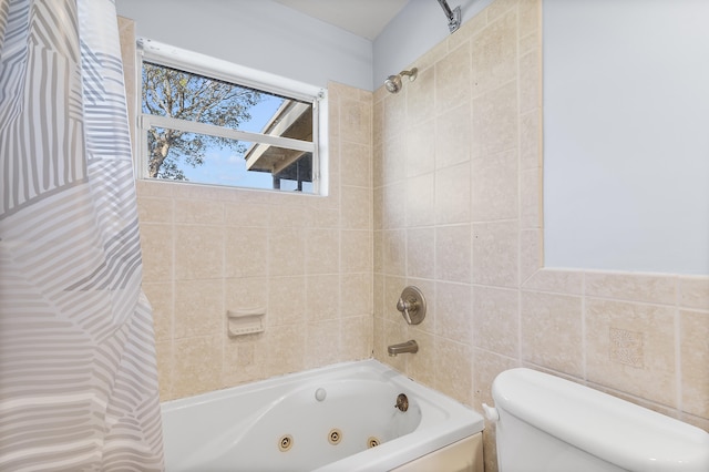 bathroom with toilet and a combined bath / shower with jetted tub