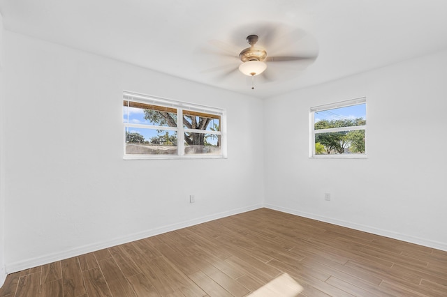 empty room featuring ceiling fan, wood finished floors, and baseboards