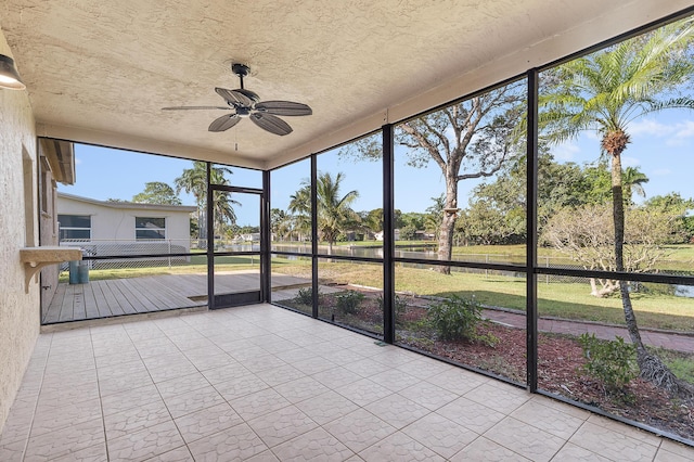 unfurnished sunroom with ceiling fan