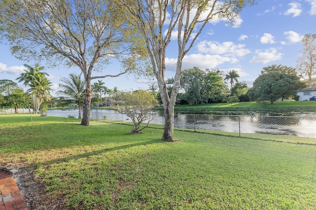 view of yard with a water view and fence