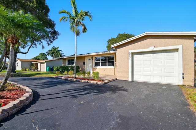 single story home with stucco siding, driveway, and a garage