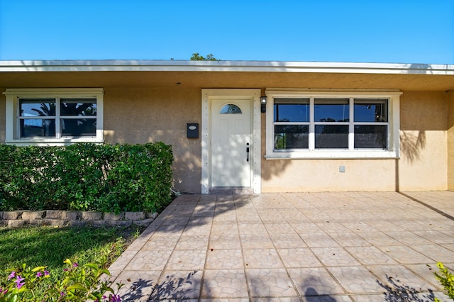 doorway to property featuring stucco siding
