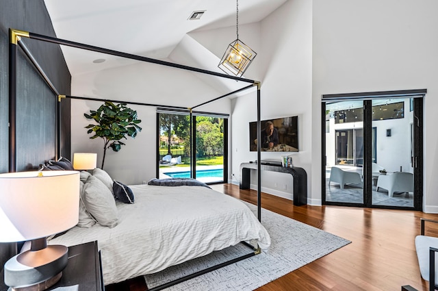 bedroom featuring high vaulted ceiling, baseboards, wood finished floors, and access to exterior