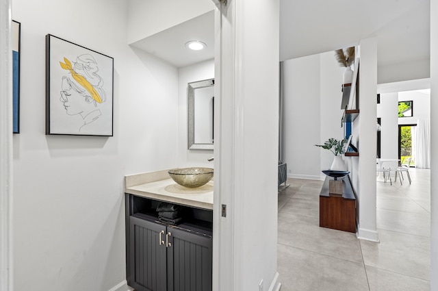 bathroom with baseboards, concrete floors, and vanity