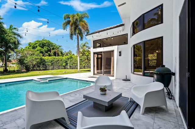 view of swimming pool featuring a patio area, a pool with connected hot tub, and fence