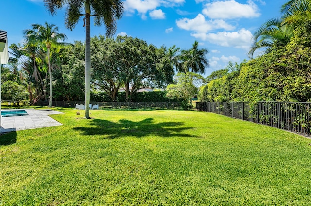 view of yard with fence, a patio area, and a fenced in pool