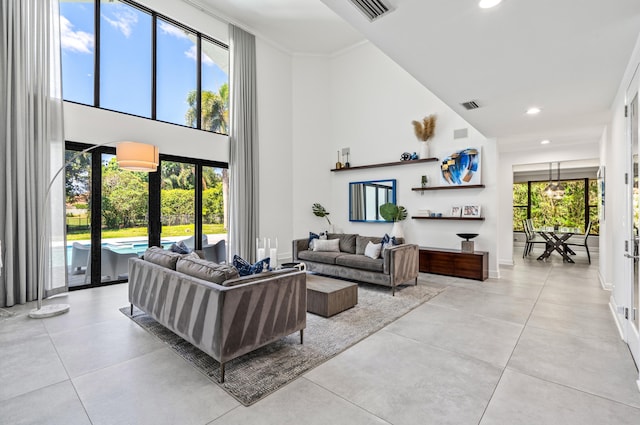 living area with recessed lighting, a towering ceiling, and plenty of natural light