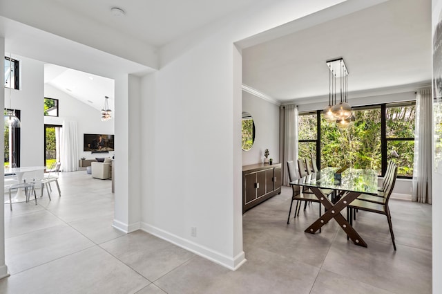 dining room featuring baseboards, a wealth of natural light, a notable chandelier, and ornamental molding