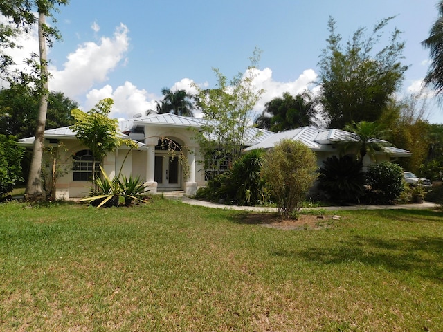 17609 72nd Rd N, The Acreage, FL 33470 - view of front of property featuring metal roof, stucco siding, a standing seam roof, and a front lawn