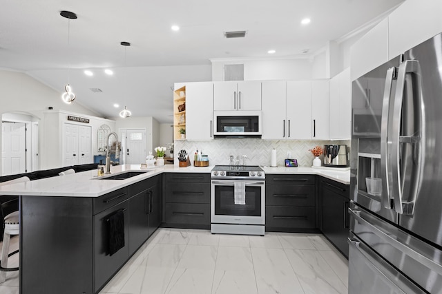 kitchen with a peninsula, visible vents, a kitchen bar, stainless steel appliances, and a sink