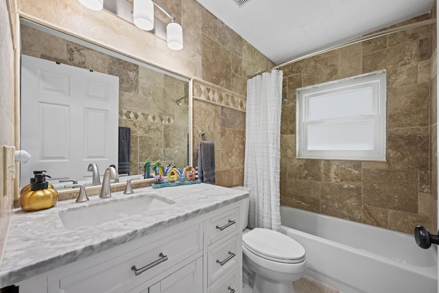 full bath featuring tile walls, toilet, vanity, and shower / bath combination with curtain