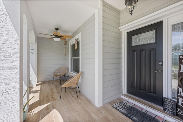 doorway to property featuring a porch and a ceiling fan