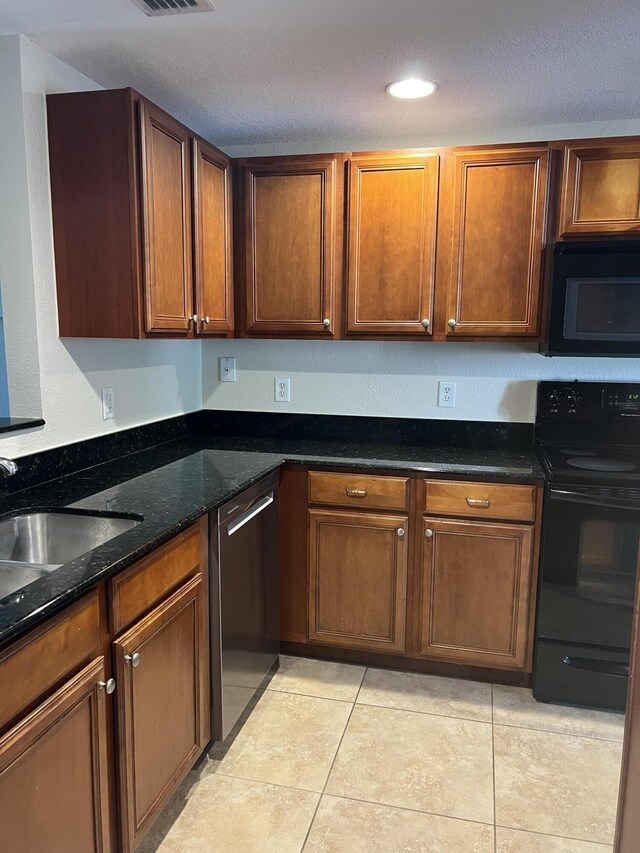 4220 Gator Trace Ave Unit 5E, Fort Pierce, FL 34982 - kitchen with dark stone counters, a sink, a textured ceiling, black appliances, and light tile patterned floors