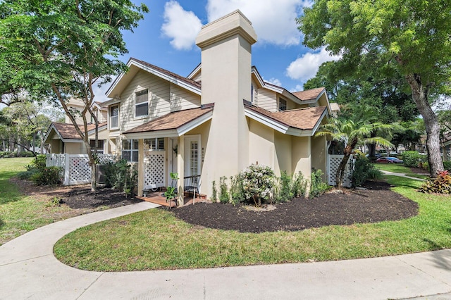 8110 Oakton Ct Unit 10B, Lake Clarke Shores, FL 33406 - view of front of property with a shingled roof, a chimney, stucco siding, and a front lawn