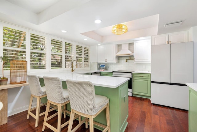 8110 Oakton Ct Unit 10B, Lake Clarke Shores, FL 33406 - kitchen with freestanding refrigerator, stainless steel electric range oven, green cabinetry, a raised ceiling, and premium range hood