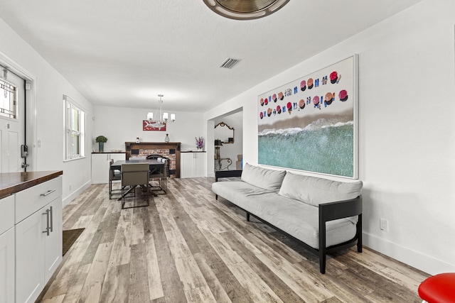 944 Hansen St, West Palm Beach, FL 33405 - living area featuring light wood finished floors, a chandelier, and baseboards