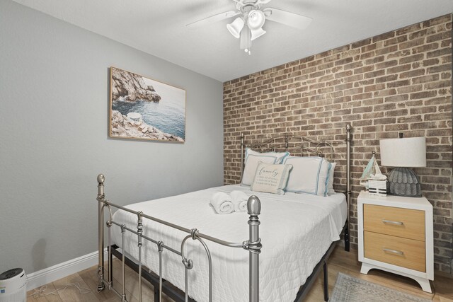 944 Hansen St, West Palm Beach, FL 33405 - bedroom featuring wood finished floors, baseboards, ceiling fan, and brick wall