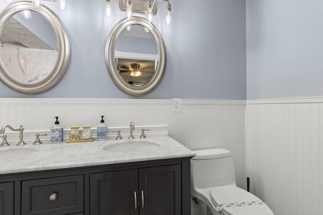 944 Hansen St, West Palm Beach, FL 33405 - full bathroom with a wainscoted wall, toilet, double vanity, and a ceiling fan
