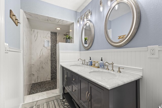 944 Hansen St, West Palm Beach, FL 33405 - bathroom with a marble finish shower, wainscoting, double vanity, and marble look tiles