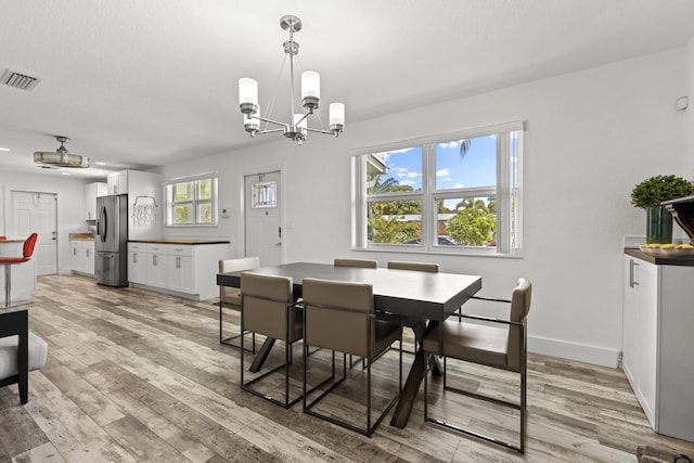 944 Hansen St, West Palm Beach, FL 33405 - dining space featuring a chandelier, light wood-type flooring, and baseboards