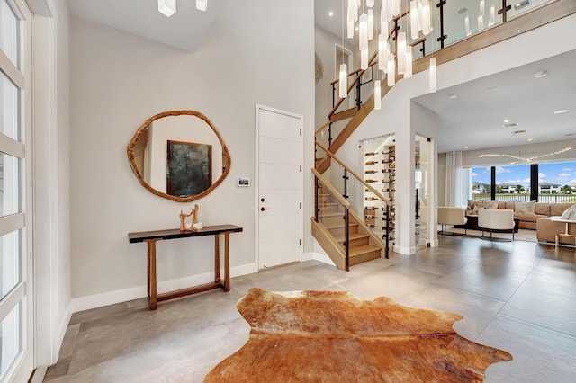 17045 Five Waters Ave, Boca Raton, FL 33496 - foyer with baseboards, a high ceiling, finished concrete flooring, and stairs