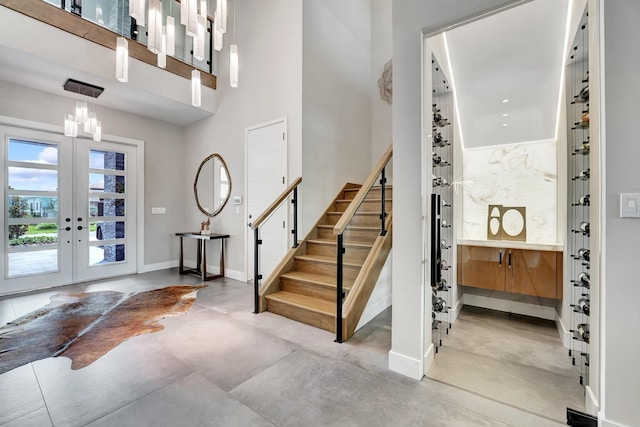 17045 Five Waters Ave, Boca Raton, FL 33496 - foyer entrance featuring french doors, concrete flooring, baseboards, and stairs
