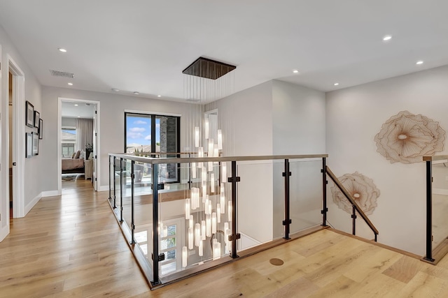 17045 Five Waters Ave, Boca Raton, FL 33496 - corridor with visible vents, light wood-style flooring, and an upstairs landing