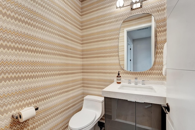 17045 Five Waters Ave, Boca Raton, FL 33496 - half bathroom with visible vents, toilet, vanity, and wallpapered walls