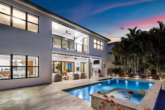 17045 Five Waters Ave, Boca Raton, FL 33496 - rear view of property with a patio area, a pool with connected hot tub, an outdoor hangout area, stucco siding, and a balcony