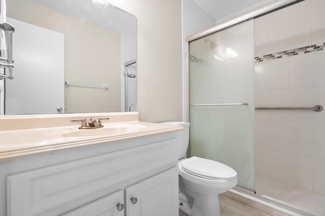 bathroom with a shower stall, tile patterned floors, vanity, and toilet