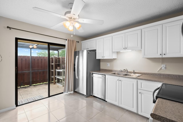 kitchen with a textured ceiling, white cabinetry, a ceiling fan, appliances with stainless steel finishes, and a sink