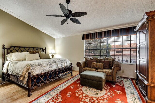 bedroom featuring baseboards, vaulted ceiling, a textured ceiling, crown molding, and wood finished floors