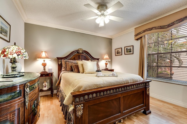 bedroom featuring light wood-style floors, baseboards, and ornamental molding